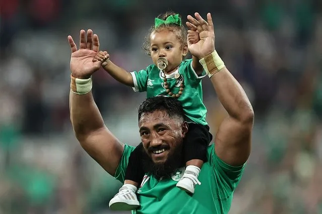 Ireland's centre Bundee Aki holds a child aloft as he celebrates after victory in the France 2023 Rugby World Cup Pool B match between Ireland and Scotland at the Stade de France in Saint-Denis, on the outskirts of Paris on October 7, 2023. (Photo by Franck Fife/AFP Photo)
