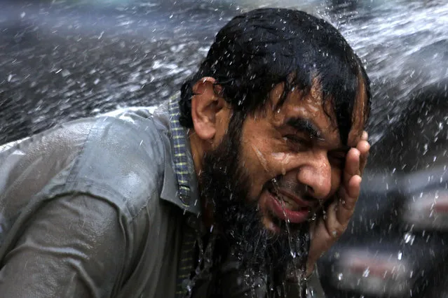 A Pakistani man cools off by pouring water on his heads at a roadside as heat wave continues in Peshawar, Pakistan, 09 June 2021. Pakistan's Meteorological Department (PMD) said the weather in the city will remain hot and humid for the next three days. (Photo by Arshad Arbab/EPA/EFE)