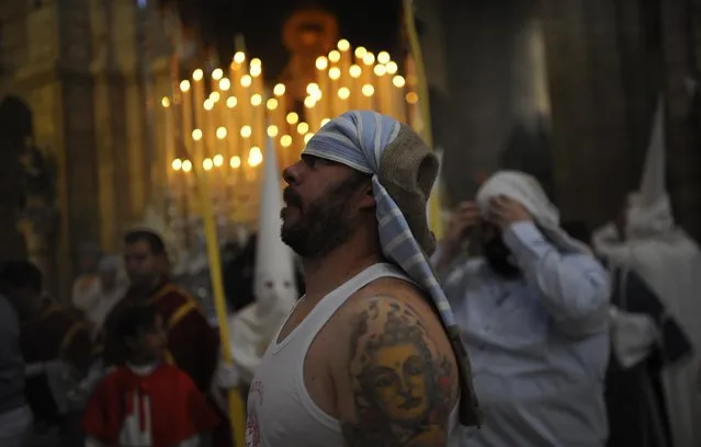 A “Costalero” from “La Borriquita” brotherhood takes part during a Holy Week procession in Cordoba, Spain, Sunday, March 29, 2015. (Photo by Manu Fernandez/AP Photo)