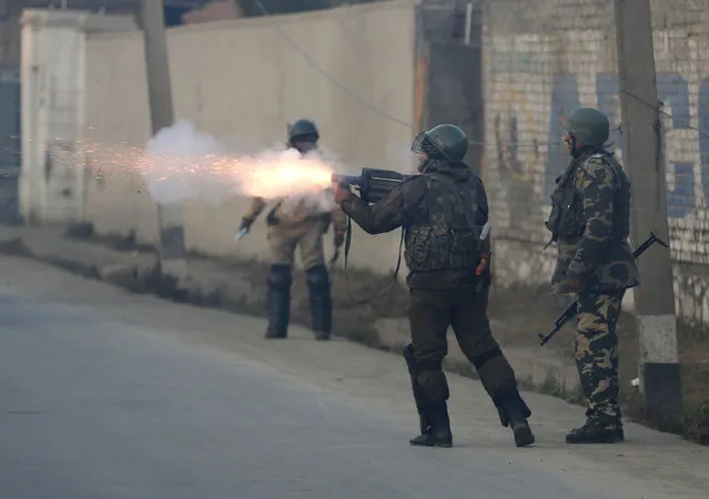 An Indian paramilitary soldier fires tear gas shells on Kashmiri protesters during a clash in Srinagar, Indian controlled Kashmir, Saturday, December 15, 2018. At least seven civilians were killed and nearly two dozens injured when government forces fired at anti-India protesters in disputed Kashmir following a gunbattle that left three rebels and a soldier dead on Saturday, police and residents said. (Photo by Mukhtar Khan/AP Photo)