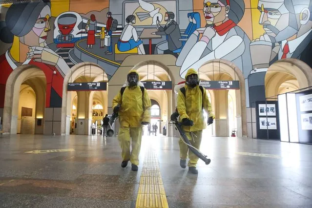 Employees of the Leader Center for High Risk Rescue Operations of the Russian Emergencies Ministry carry out disinfection of Leningradsky Railway Station in Moscow, Russia on July 22, 2021 amid the COVID-19 pandemic. (Photo by Sergei Karpukhin/TASS)