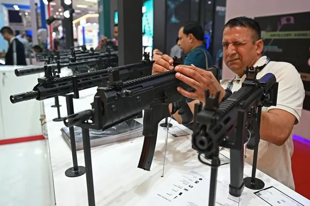 A visitor inspects a gun kept on display at the Milipol India 2023 Internal Homeland Security Expo in New Delhi on October 26, 2023. (Photo by Arun Sankar/AFP Photo)
