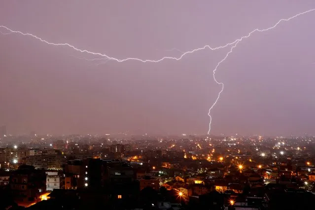 Lightnings flash over Tirana, Albania on April 24, 2023. (Photo by Florion Goga/Reuters)
