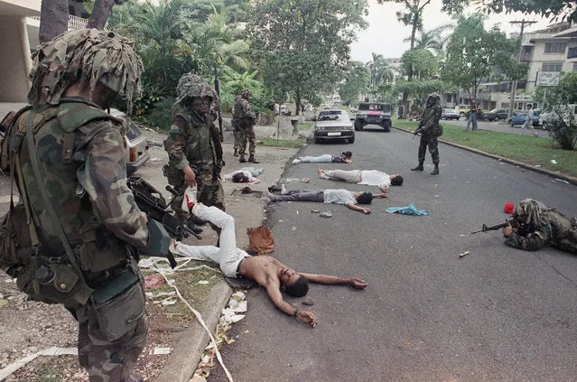 In this December 26, 1989 file photo, U.S. soldiers take aim while searching suspects detained outside the home of a business associate of Manuel Noriega in Panama City. In 1989, the U.S. invaded Panama to oust strongman Manuel Noriega. (Photo by Ezequiel Becerra/AP Photo)