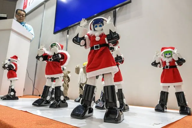 Robots dressed in Santa Claus costumes perform a dance routine at the “Sagami Robot Town” display on the first day of the 2023 International Robot Exhibition at the Tokyo International Exhibition Center in Tokyo on November 29, 2023. (Photo by Richard A. Brooks/AFP Photo)