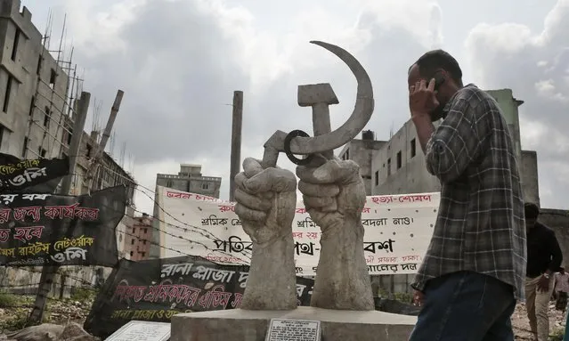 In this Monday, April 20, 2015 photo, a Bangladeshi man walks near a monument erected in memory of the victims of Rana Plaza building collapse, the worst in the history of the garment industry in Savar, near Dhaka, Bangladesh. Human Rights Watch has criticized the Bangladeshi government for failing to protect workers, saying not enough is being done to eliminate assault, intimidation and other abuses still common in the garment industry. (Photo by A. M. Ahad/AP Photo)