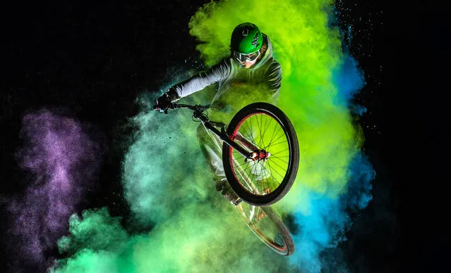 The biker with the holi powder behind whilst performing stunts. (Photo by Christoph Jorda/Caters News)