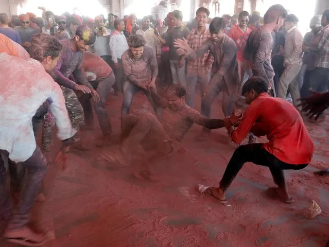 Men daubed in colours celebrates “Lathmar Holi” inside a temple in the town of Barsana, in Uttar Pradesh, India, March 15, 2019. (Photo by Altaf Hussain/Reuters)