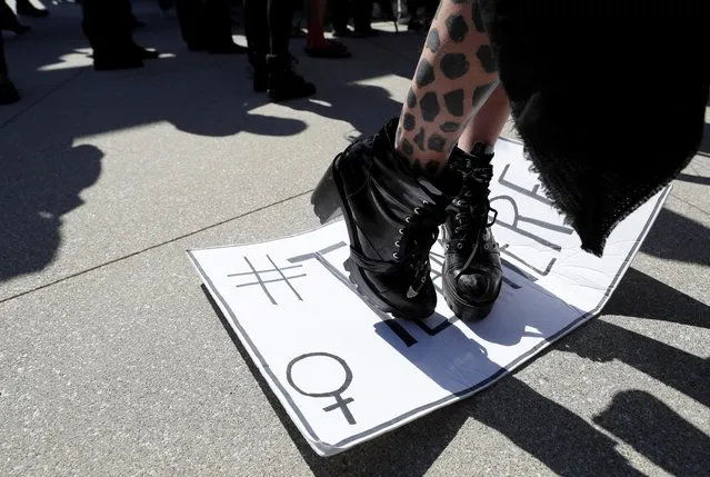 An activist stands on the counter protesters' placard during a rally in support of the Netflix transgender employee walkout “Stand Up in Solidarity” to protest the streaming of comedian Dave Chappelle's new comedy special, in Los Angeles, California, U.S. October 20 2021. (Photo by Mario Anzuoni/Reuters)