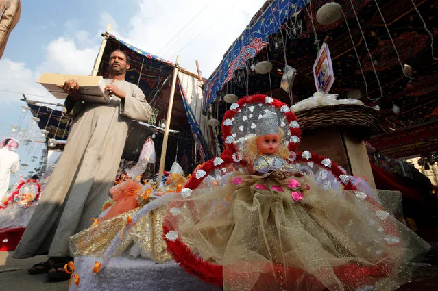 A vendor selling traditional sweets and “Aroset El Moulid” (Bride of Moulid) dolls waits for customers at a market ahead of the religious holiday of Mawlid al-Nabi, the birthday of Prophet Mohammad, in Old Cairo, Egypt December 8, 2016. (Photo by Amr Abdallah Dalsh/Reuters)