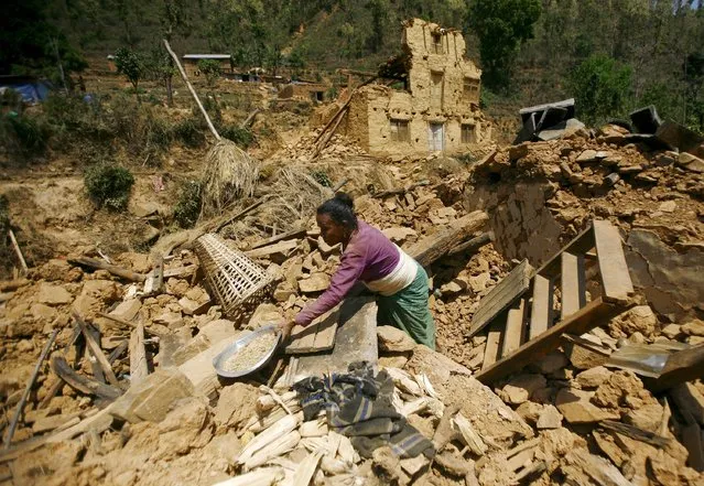 An earthquake victim clears the debris of her collapsed house at a village in Sindhupalchowk, Nepal, May 5, 2015. (Photo by Gopen Rai/Reuters)