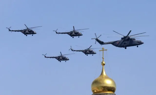 A Mi-26 heavy transport helicopter and Mi-8 military helicopters fly in formation during the Victory Day parade above Red Square in Moscow, Russia, May 9, 2015. (Photo by Tatyana Makeyeva/Reuters)