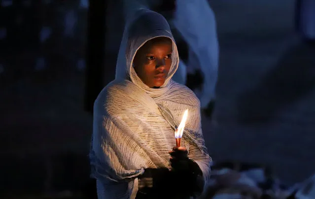 An Ethiopian Orthodox faithful holds candles during the Easter eve prayers at the Holy Trinity Cathedral Orthodox church in Addis Ababa, Ethiopia, April 28, 2019. (Photo by Tiksa Negeri/Reuters)