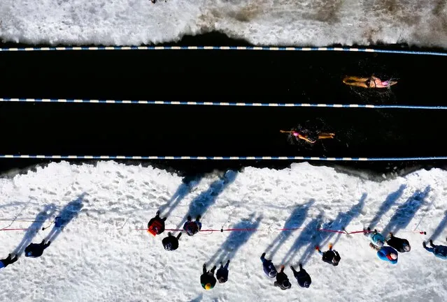 In a photograph taken with a drone, competitors take part in the 200 meter swim portion of the Annual Winter Swimming Festival at Lake Memphremagog in Newport, Vermont, USA, 23 February 2024. Every year for the past decade, dozens of swimmers have braved the frigid waters of Lake Memphremagog, which straddles the border between Canada and the United States, for the annual winter swim festival.  (Photo by Cj Gunther/EPA/EFE)