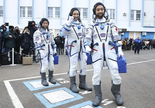 In this photo released by the Roscosmos Space Agency, Roscosmos cosmonaut Alexander Misurkin, center, and spaceflight participants Yusaku Maezawa, left, and Yozo Hirano, right, of Japan, members of the main crew of the new Soyuz mission to the International Space Station (ISS) walk prior to the launch at the Russian leased Baikonur cosmodrome, Kazakhstan, Wednesday, December 8, 2021. (Photo by Pavel Kassin/Roscosmos Space Agency via AP Photo)