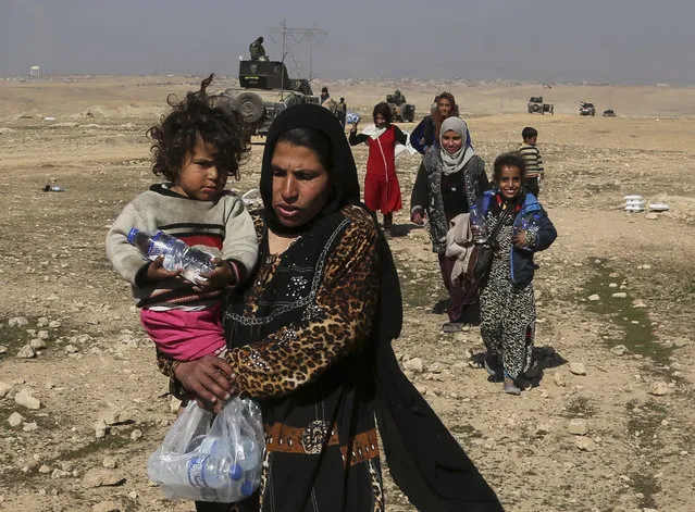 Displaced Iraqis flee their homes due to fighting between Iraqi special forces and Islamic State militants, on the western side of Mosul, Iraq, Thursday, February 23, 2017. The Iraqi security forces advance comes as part of a major assault that started five days earlier to drive Islamic State militants from the western half of Mosul, Iraq's second-largest city. (Photo by Khalid Mohammed/AP Photo)