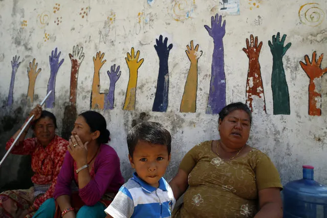 Nepalese earthquake survivors take a rest at the devastated area in Bungamati, Nepal, 14 May 2015. People in Nepal started cautiously returning to their daily life two days after the Himalayan nation was hit by its second major earthquake in three weeks. Affected children were “facing an unprecedented emotional toll” from the double trauma, the United Nations warned. (Photo by Mast Irham/EPA)