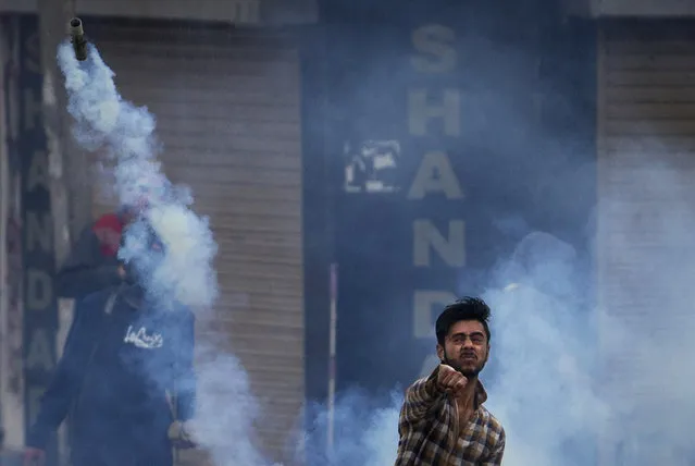 A Kashmiri Muslim protester throws back an exploded tear gas shell at Indian policemen during a protest in Srinagar, Indian controlled Kashmir, Friday, April 8, 2016. Police fired teargas and pellet guns to disperse Kashmiris who gathered after Friday afternoon prayers to protest against Indian control over a part of the disputed region of Kashmir. (Photo by Dar Yasin/AP Photo)