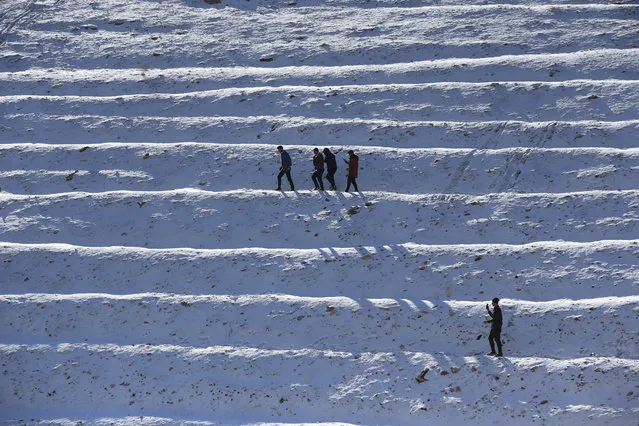 People walk at snow covered place after a snowfall in Sulaymaniyah, Iraq on January 10, 2019. (Photo by Feriq Ferec/Anadolu Agency/Getty Images)