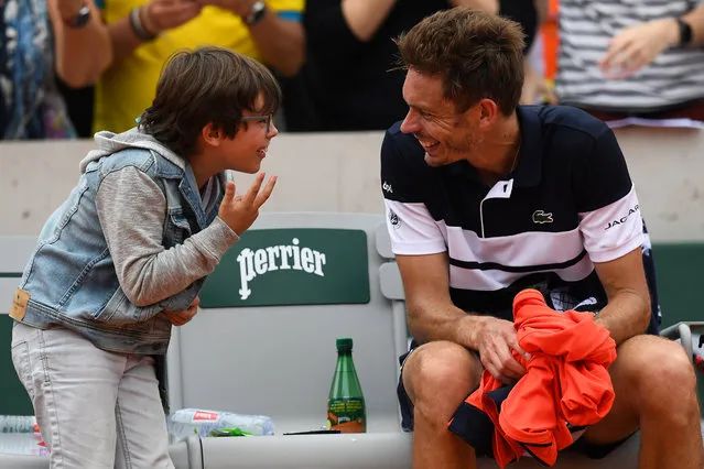 France's Nicolas Mahut celebrates with his son after winning against Italy's Marco Cecchinato during their men's singles first round match on day 1 of The Roland Garros 2019 French Open tennis tournament in Paris on May 26, 2019. (Photo by Christophe Archambault/AFP Photo)