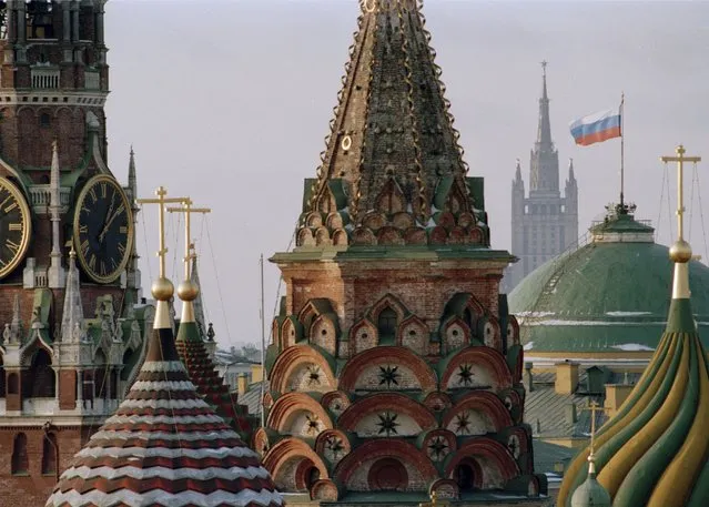 The Russian flag flies over the Kremlin between the spires of St. Basil's Cathedral in Moscow, on Thursday, December 26, 1991. After Soviet President Mikhail Gorbachev stepped down on Dec. 25, 1991, people strolling across Moscow's snowy Red Square on the evening of Dec. 25 were surprised to witness one of the 20th century’s most pivotal moments – the Soviet red flag over the Kremlin pulled down and replaced with the Russian Federation's tricolor. (Photo by Alexander Zemlianichenko/AP Photo/File)