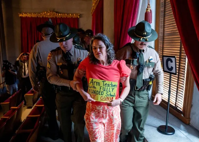 Tennessee State Troopers remove gun reform activist Allison Polidor from the House Gallery at the Tennessee State Capitol building after Speaker of the House, Republican Cameron Sexton, ordered the gallery cleared, she was detained and later cited. Gun reform activists gathered to protest HB1202 which would authorize teachers, principals, and school personnel to carry a concealed handgun on school grounds in Nashville, Tennessee on April 18, 2024. (Photo by Seth Herald/Reuters)