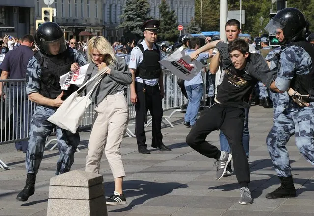 Police officers detain people during an unsanctioned rally in the center of Moscow, Russia, Saturday, July 27, 2019. Russian police on Saturday began arresting people outside the Moscow mayor's office ahead of an election protest demanding that opposition candidates be allowed to run for the Moscow city council. (Photo by Alexander Zemlianichenko/AP Photo)