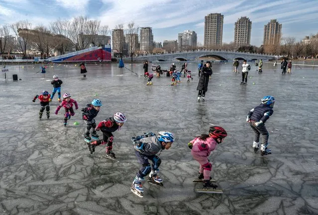 Young children take part in speed skating lessons at an outdoor rink at a local park on January 8, 2022 in Beijing, China. (Photo by Kevin Frayer/Getty Images)