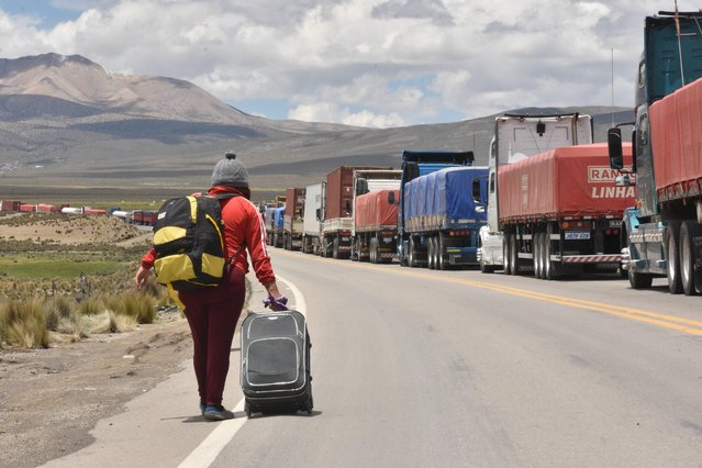 Dozens of trucks wait to cross the border into Chile, in Tambo Quemado, Bolivia, 13 January 2022. A commission from the Government of Bolivia arrived at Tambo Quemado, the main border post with Chile, to deliver food and medical support to hundreds of carriers who have been waiting for days to take Covid-19 tests on the Chilean side. (Photo by EPA-EFE/Stringer)