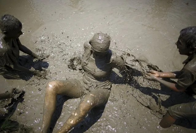 Children splash mud on a tourist as they take part in the Asar Pandhra festival in Pokhara valley, west of Nepal's capital Kathmandu, June 30, 2015. (Photo by Navesh Chitrakar/Reuters)
