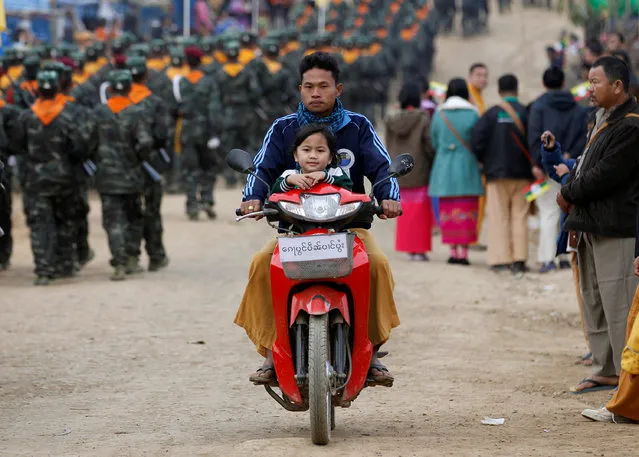 A girl rides on a motorcycle with her father as soldiers from the Shan State Army-South march in formation during a military parade celebrating the 69th Shan State National Day at Loi Tai Leng, the group's headquarters, on the Thai-Myanmar border February 7, 2016. (Photo by Soe Zeya Tun/Reuters)