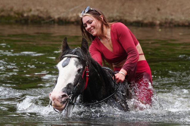 A woman rides her horse through the river at the Appleby Horse Fair, the annual gathering of gypsies and travellers in Appleby, Cumbria on Thursday, June 6, 2024. (Photo by Owen Humphreys/PA Wire)