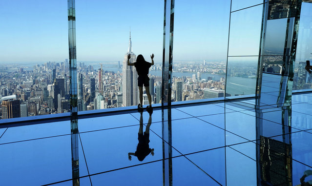 People look out at the city among 30,375 square feet of mirrors at SUMMIT One Vanderbilt in New York on May 22, 2024. The Parade of Ships is seen from SUMMIT One Vanderbilt in NYC as part of the Fleet Week Celebration events. (Photo by Timothy A. Clary/AFP Photo)