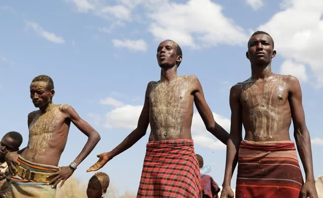 Turkana warriors stand stand during a cleansing ceremony after finding footprints of Nyangatom warriors around their settlement in Ilemi Triangle, Kenya, July 15, 2019. (Photo by Goran Tomasevic/Reuters)