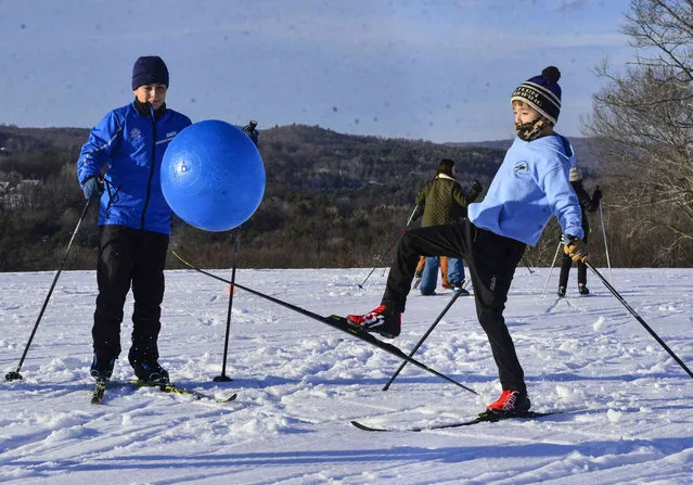 Spencer Jones, 11, a member of the Putney Ski Club, uses his skis to kick around a ball as a warm-up before going out on the trails at The Putney School in Putney, Vt., on Wednesday, February 2, 2022. (Photo by Kristopher Radder/The Brattleboro Reformer via AP Photo)