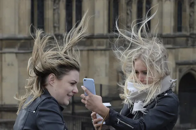 Women attempt to take a selfie amid strong winds on Westminster Bridge, London, Thursday, February 23, 2017. Flights have been cancelled and commuters were warned they faced delays after Storm Doris reached nearly 90mph. (Photo by Stefan Rousseau/PA Wire via AP Photo)