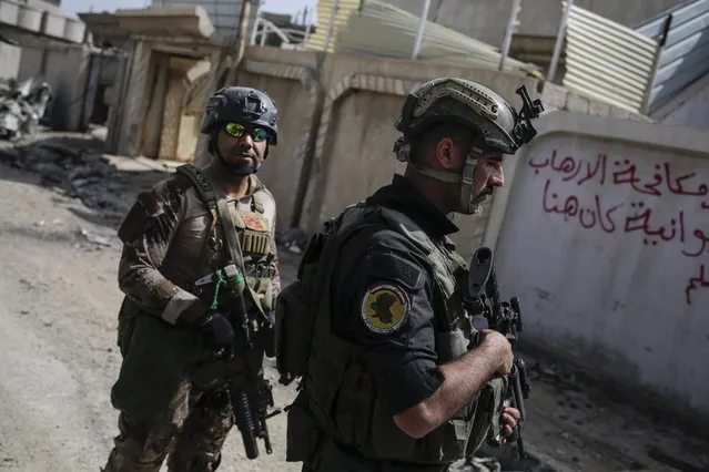 Soldier with the Iraqi special forces walk through the streets of Mosul as fighting between Iraqi forces and the Islamic State group continues on Saturday, April 22, 2017. (Photo by Bram Janssen/AP Photo)