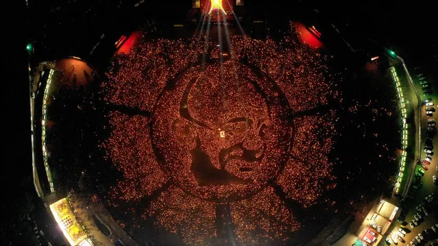 A handout photo made available by the Gandhinagar Cultural Forum shows an aerial view of some 30,000 Hindu devotees holding lighted oil lamps composing a portrait of Mahatma Gandhi to commemorate his 150th birth anniversary during a Maha Aarti Hindu ritual near Gandhinagar, Ahmedabad, Gujarat, India, 06 October 2019 (issued 07 October 2019). According to Shri Krashnakant Jha, President of the Gandhinagar Cultural Forum, the event was webcasted live and scores of people witnessed it across the globe. A series of celebrations marking Mahatma Gandhi's 150th birth anniversary took place after the actual day on 02 October. (Photo by Gandhinagar Cultural Forum Handout/EPA/EFE)