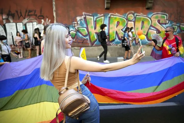 A young woman shoots a selfie picture during the Bucharest Pride 2021 in Bucharest, Romania, Saturday, August 14, 2021. The 20th anniversary of the abolishment of Article 200, which authorized prison sentences of up to five years for same-s*x relations, was one cause for celebration during the gay pride parade and festival held in Romania's capital this month. People danced, waved rainbow flags and watched performances at Bucharest Pride 2021, an event that would have been unimaginable a generation earlier. (Photo by Vadim Ghirda/AP Photo)
