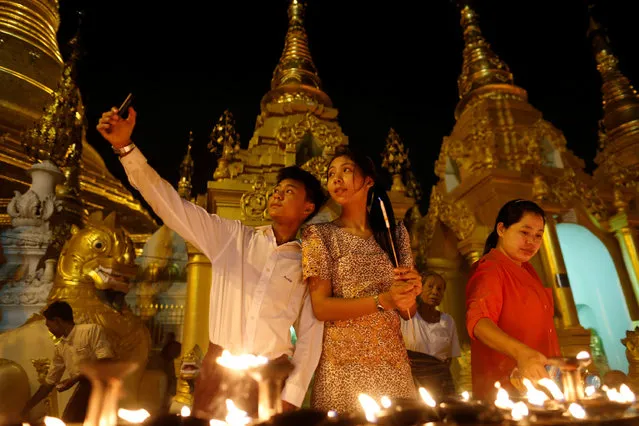 A family takes a seflie as they visit the Shwedagon Pagoda during Kason Watering Festival celebrations, also know as Vesak Day, in Yangon, Myanmar May 10, 2017. (Photo by Soe Zeya Tun/Reuters)