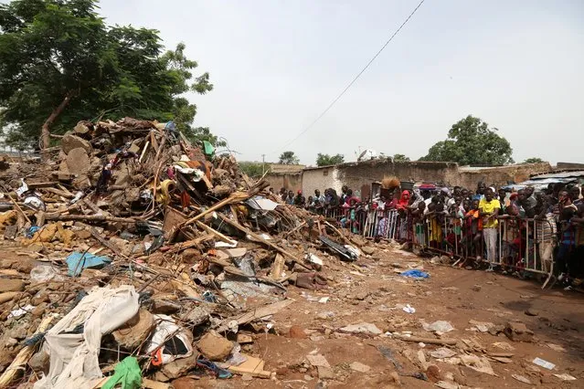 People gather outside a cordoned-off area at the site of a collapsed building in Bamako, Mali on September 2, 2019. (Photo by Annie Risemberg/Reuters)