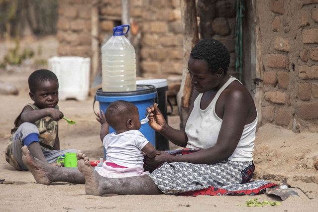 Children eat porridge prepared at a feeding center in Mudzi, Zimbabwe, on July 2, 2024. In Zimbabwe, an El Nino-induced drought is affecting millions of people, and children are most at risk. (Photo by Aaron Ufumeli/AP Photo)