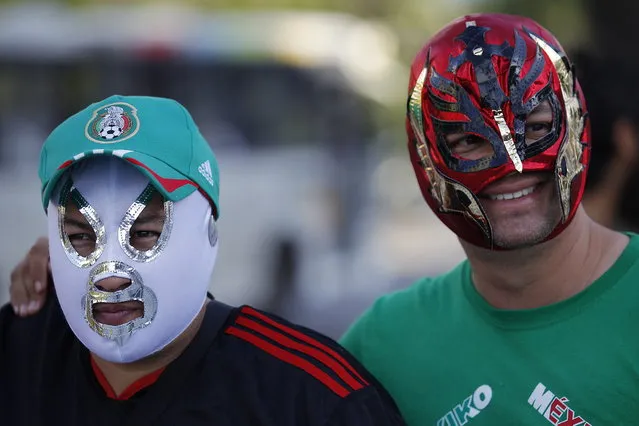 Mexican soccer fans pose for the photo wearing wrestling masks in front of Maracana stadium, in Rio de Janeiro, Brazil, Wednesday, June 11, 2014. The World Cup soccer tournament starts Thursday. (Photo by Leo Correa/AP Photo)