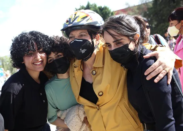 Mexican Deputy Foreign Minister Martha Delgado hugs members of an Afghanistan's robotics team Lida Azizi, Saghar Salehi and Kawsar Roshan, who arrived to Mexico in August, after a bicycle tour in Mexico City, Mexico on September 19, 2021. (Photo by Raquel Cunha/Reuters)