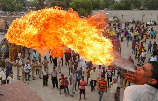 A Hindu devotee performs a stunt with fire during the Jal Yatra procession ahead of the annual Rath Yatra, or chariot procession, which will be held on June 25, in Ahmedabad, India, June 9, 2017. (Photo by Amit Dave/Reuters)