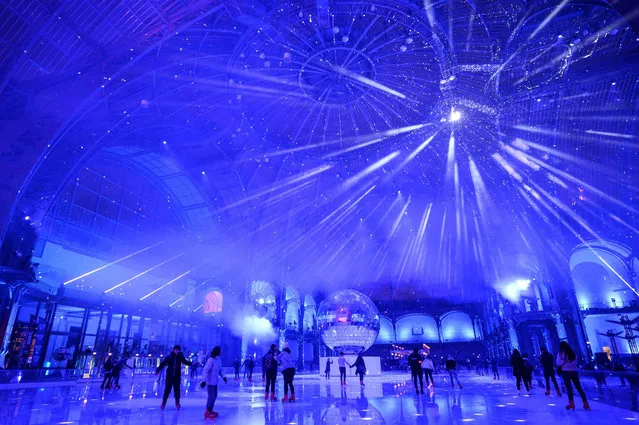 People skate on the ice skating rink hosted at the glass-roofed central hall of the Grand Palais in Paris, on December 17, 2019. (Photo by Thomas Samson/AFP Photo)