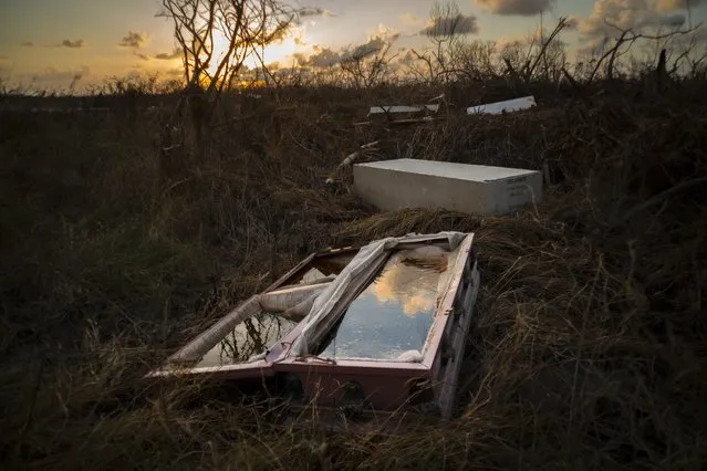 A shattered and water-filled coffin lays exposed to the elements in the aftermath of Hurricane Dorian, at the cemetery in Mclean's Town, Grand Bahama, Bahamas, Wednesday September 11, 2019. Bahamians are tackling a massive clean-up a week after Hurricane Dorian devastated the archipelago’s northern islands. (Photo by Ramon Espinosa/AP Photo)