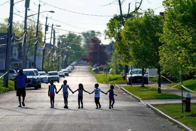 Children walk hand in hand out near the scene of a shooting at a supermarket in Buffalo, N.Y., Sunday, May 15, 2022. (Photo by Matt Rourke/AP Photo)