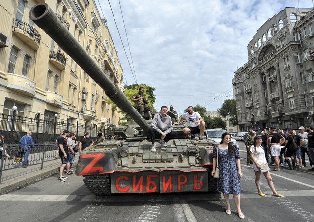 People pose for photos on a tank reading 'Siberia' as servicemen from private military company (PMC) Wagner Group block a street in downtown Rostov-on-Don, southern Russia, 24 June 2023. Security and armoured vehicles were deployed after Wagner Group's chief Yevgeny Prigozhin said in a video that his troops had occupied the building of the headquarters of the Southern Military District, demanding a meeting with Russia’s defense chiefs. (Photo by Arkady Budnitsky/EPA)