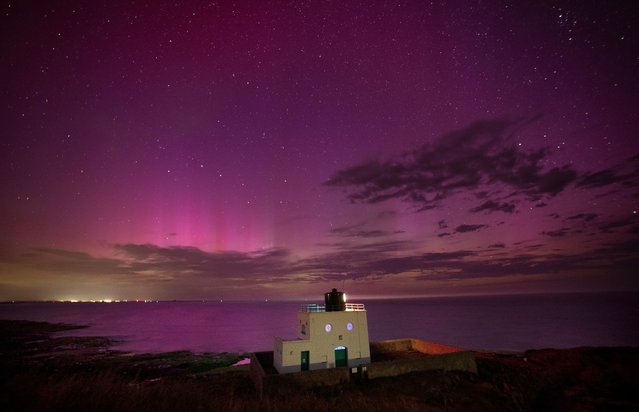 The aurora borealis, also known as the northern lights, appears over Bamburgh Lighthouse, in Northumberland on the North East coast of England on Monday, August 12, 2024. (Photo by Owen Humphreys/PA Images via Getty Images)